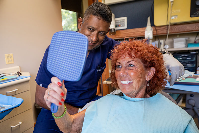mature woman smiling after receiving porcelain veneers