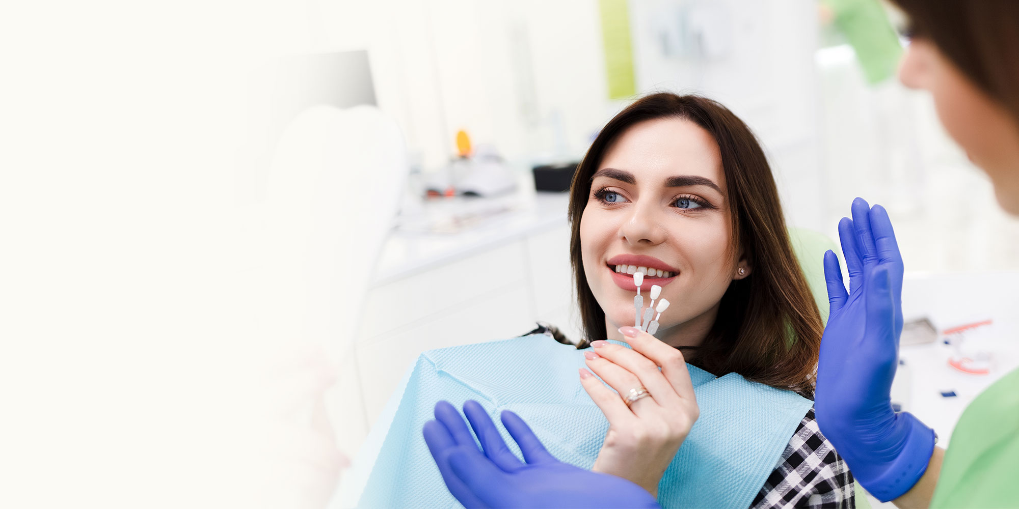 dental patient with porcelain veneers smiling in exam chair